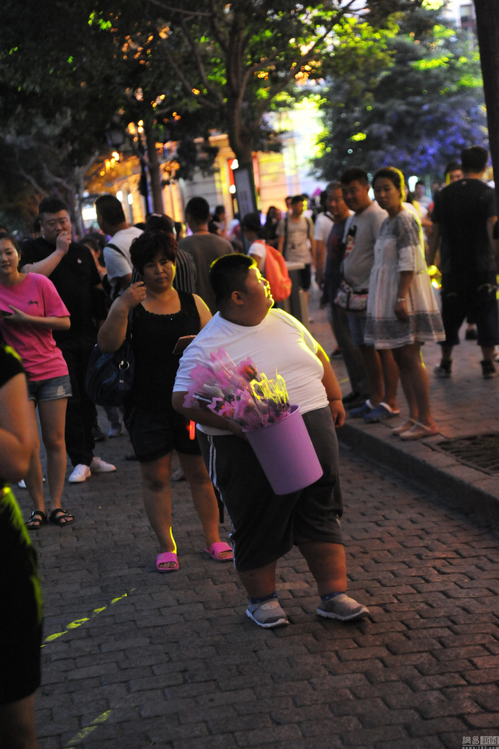 2016年8月9日,哈尔滨,小李航在街头卖花锻炼身体.