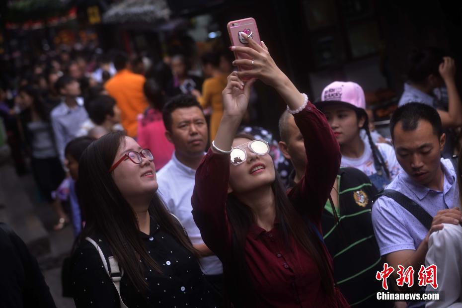游客在人群中玩自拍. 陈超 摄