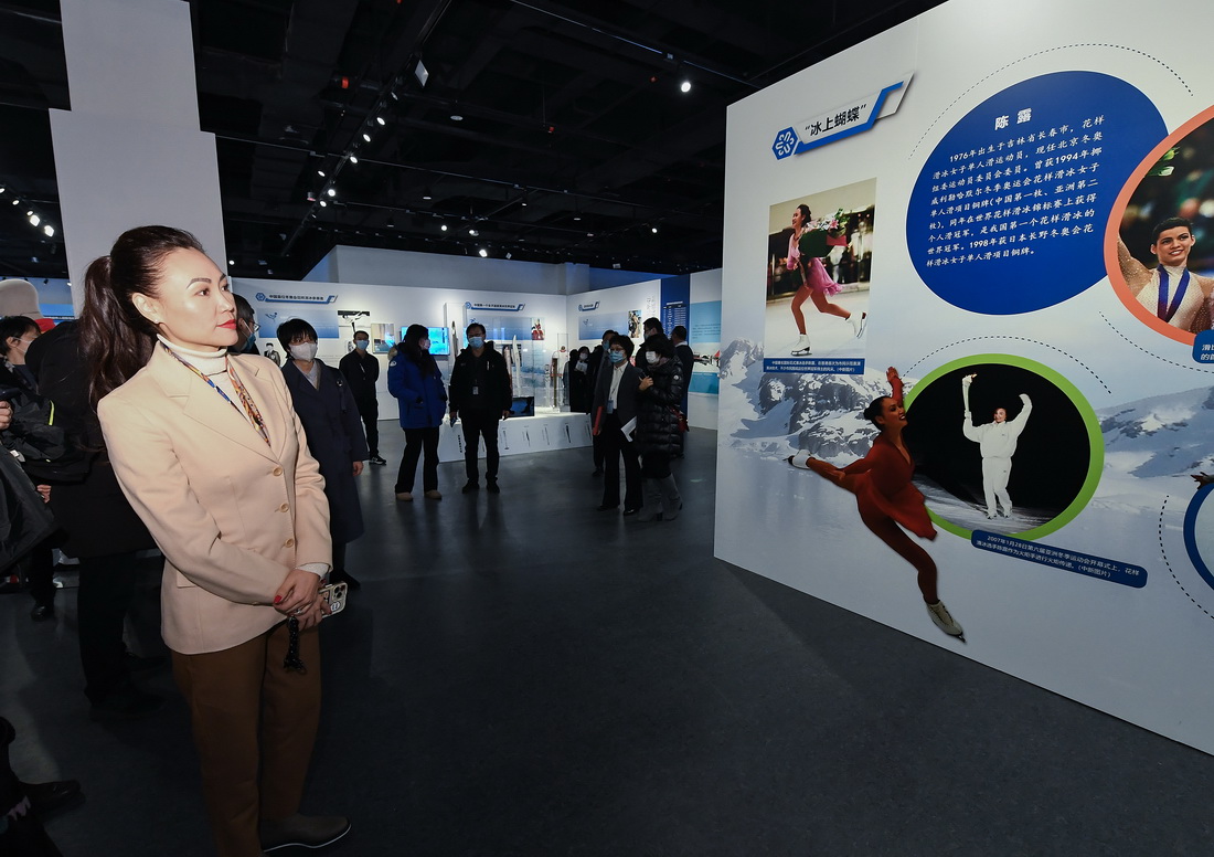 1月20日，北京冬奥组委运动员委员会委员、花样滑冰世界冠军陈露（前）在展板前驻足观看。