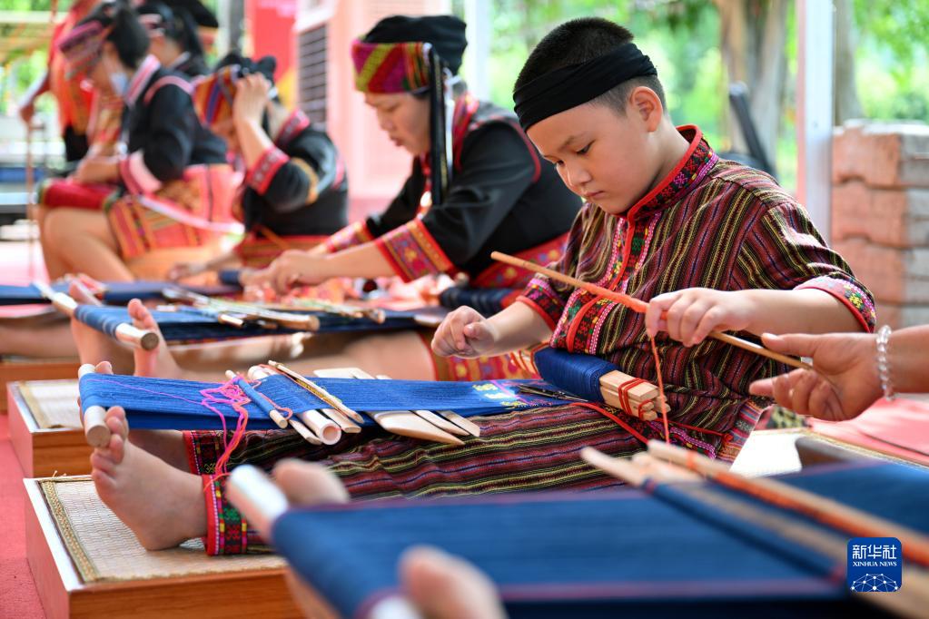 6月11日，一名小朋友在展示黎族织锦技艺。
