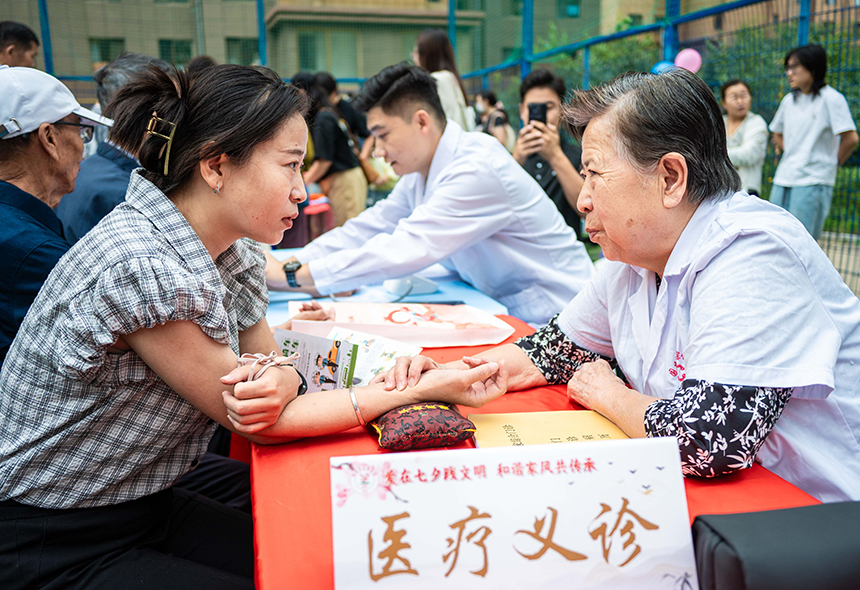 呼和浩特市玉泉区“爱在‘七夕’践文明 和谐家风共传承”主题文明市集活动现场，医护志愿者正在为市民进行中医诊疗。丁根厚摄